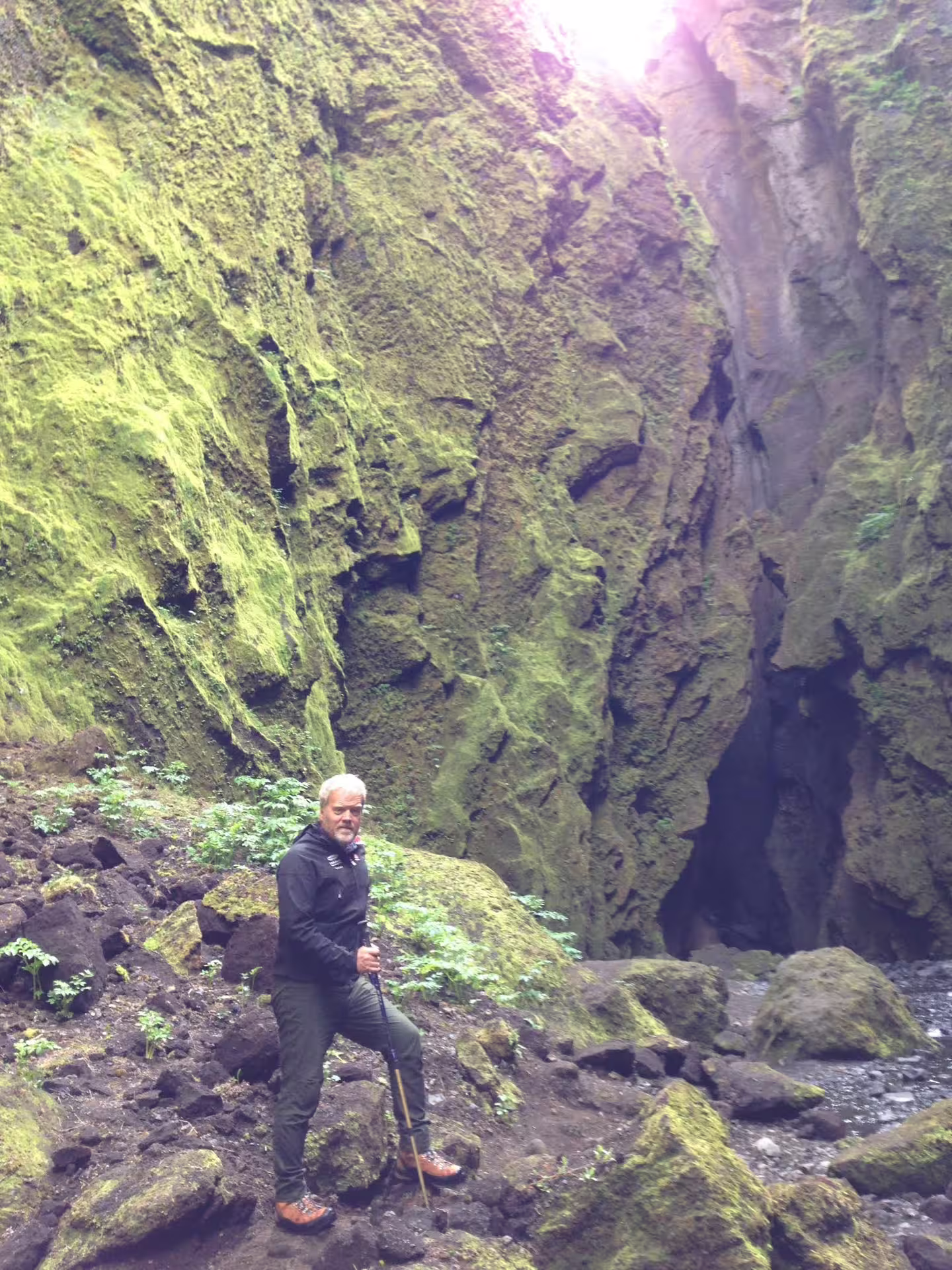 Hiker with trekking pole standing in mossy Thorsmork canyon gorge during Super Jeep day trip