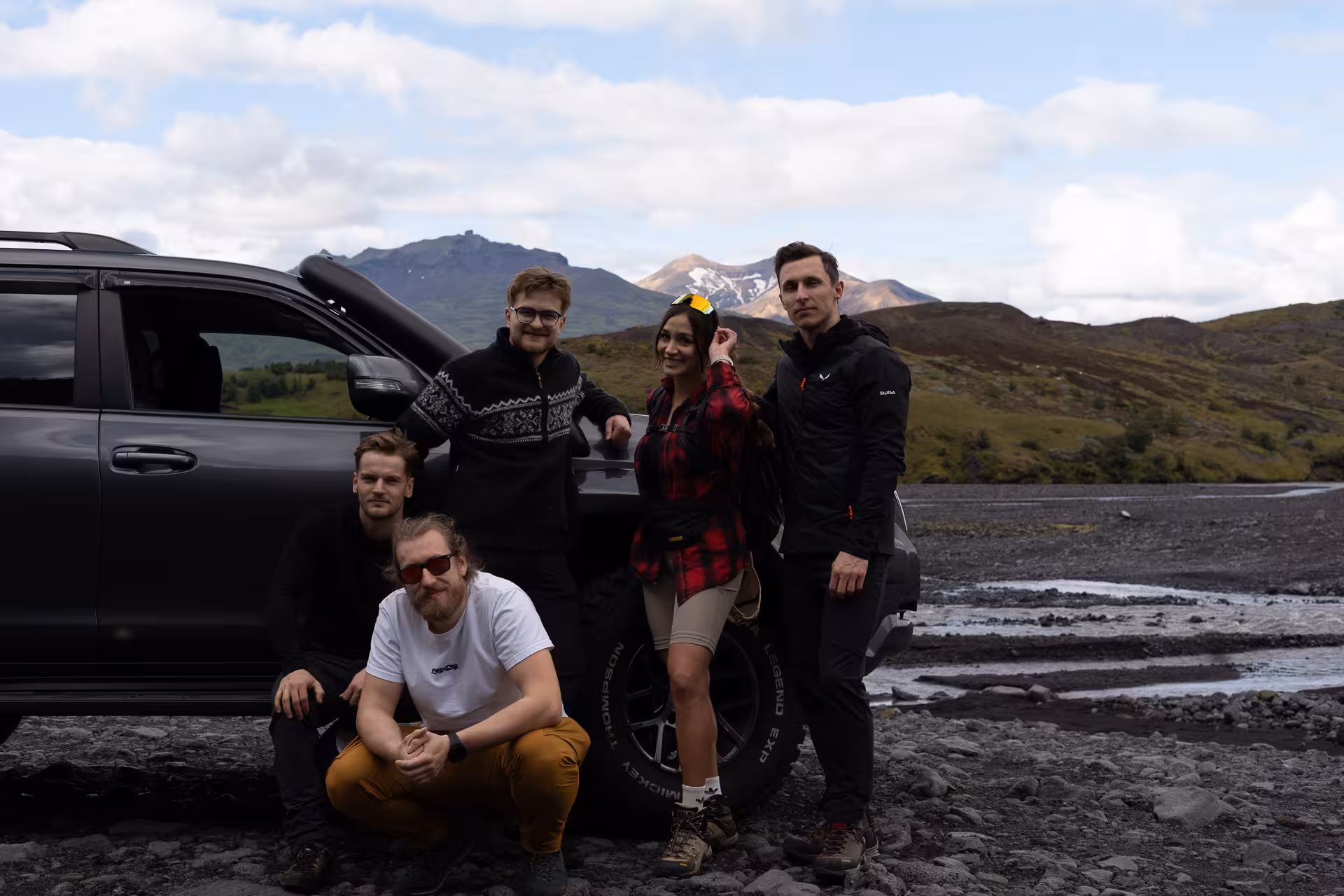 Travelers posing by 4x4 at river crossing in Þórsmörk, Iceland private off-road tour in the highlands