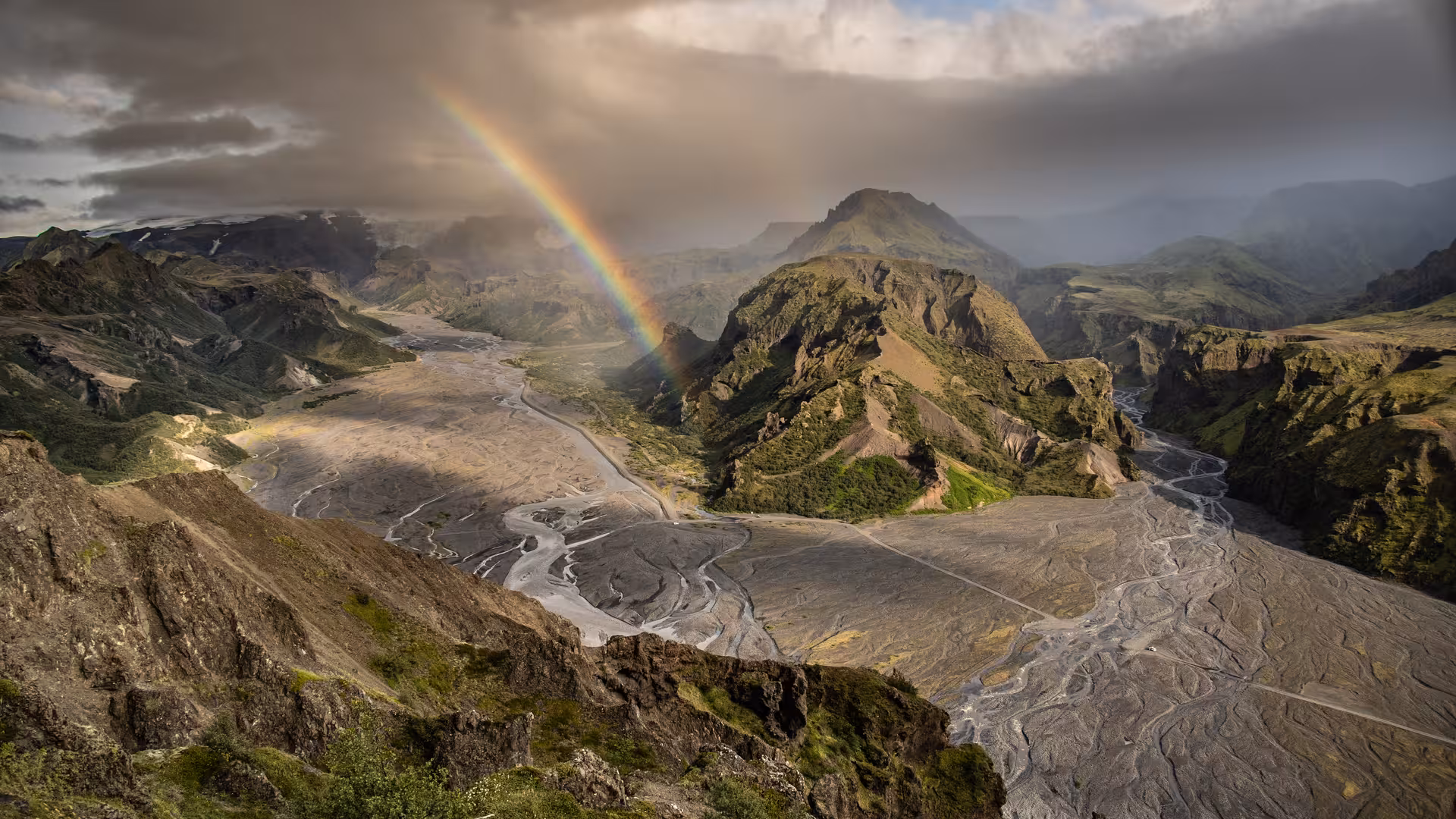 Rainbow over Thorsmork valley with braided glacial rivers and green mountains in Iceland
