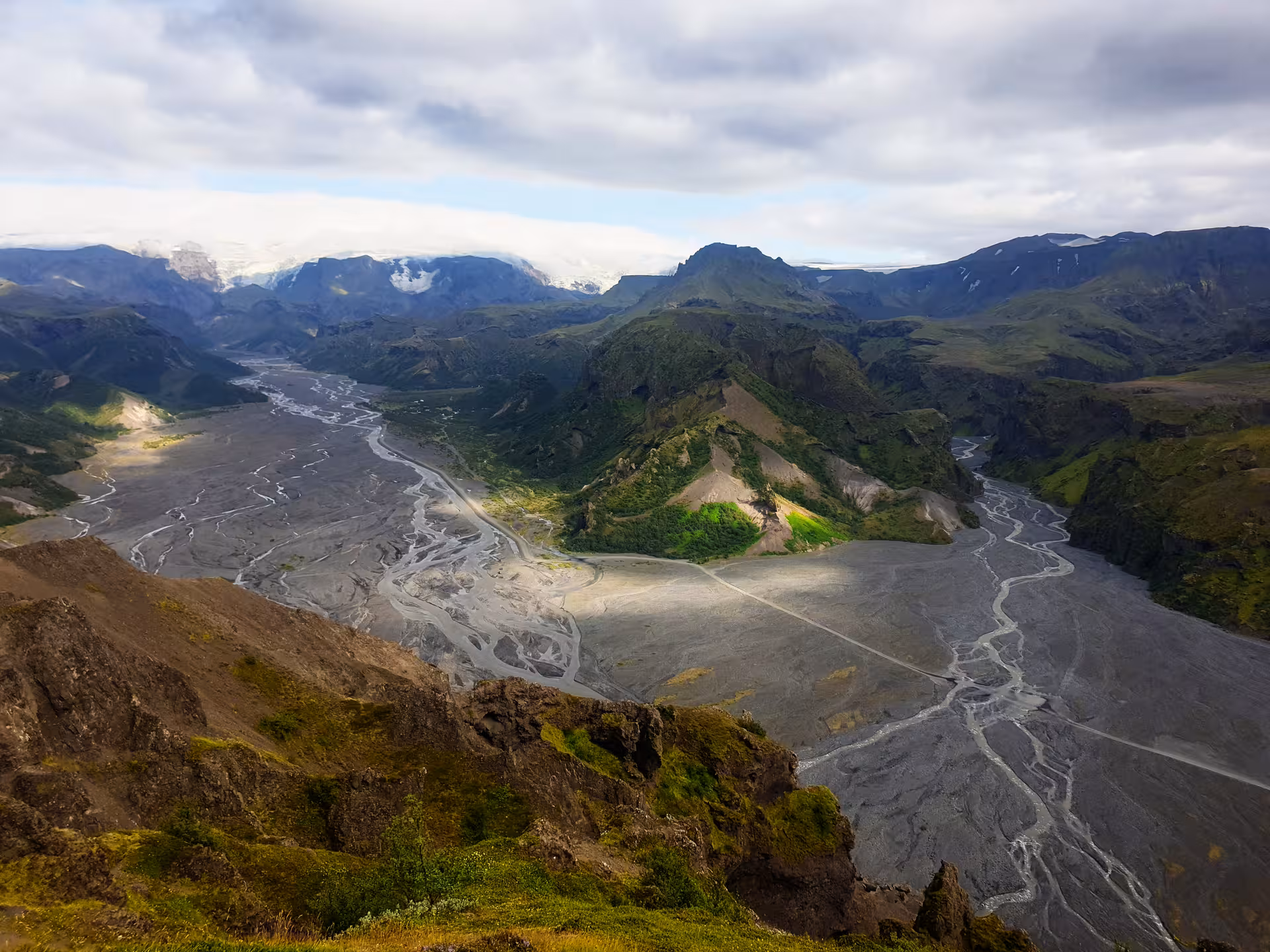 Aerial view of Thorsmork valley with braided glacial rivers, green mountains, and Eyjafjallajokull glacier in Iceland