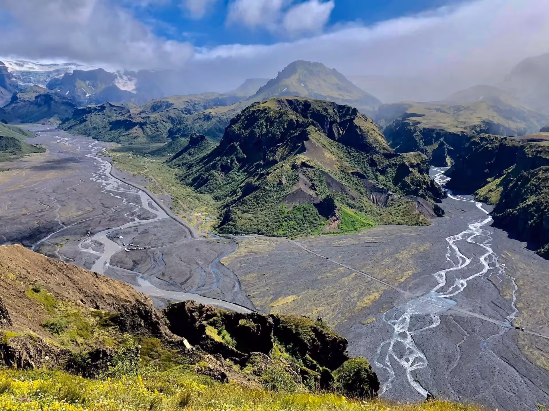 Aerial view of Thorsmork valley with braided glacial rivers, black volcanic plains, and green mountains in Iceland