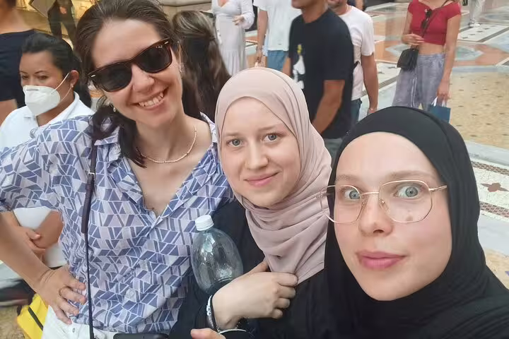 Three smiling women posing together on a self-guided walking tour in Milan