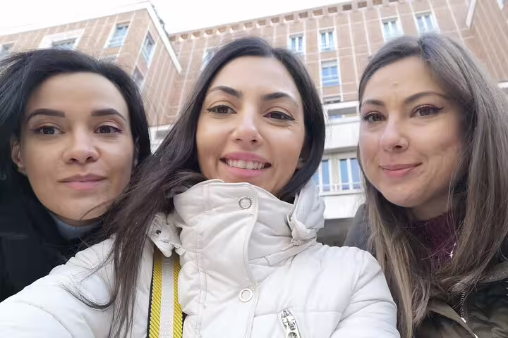 Three women taking a selfie together during a self-guided walking tour in Milan city center