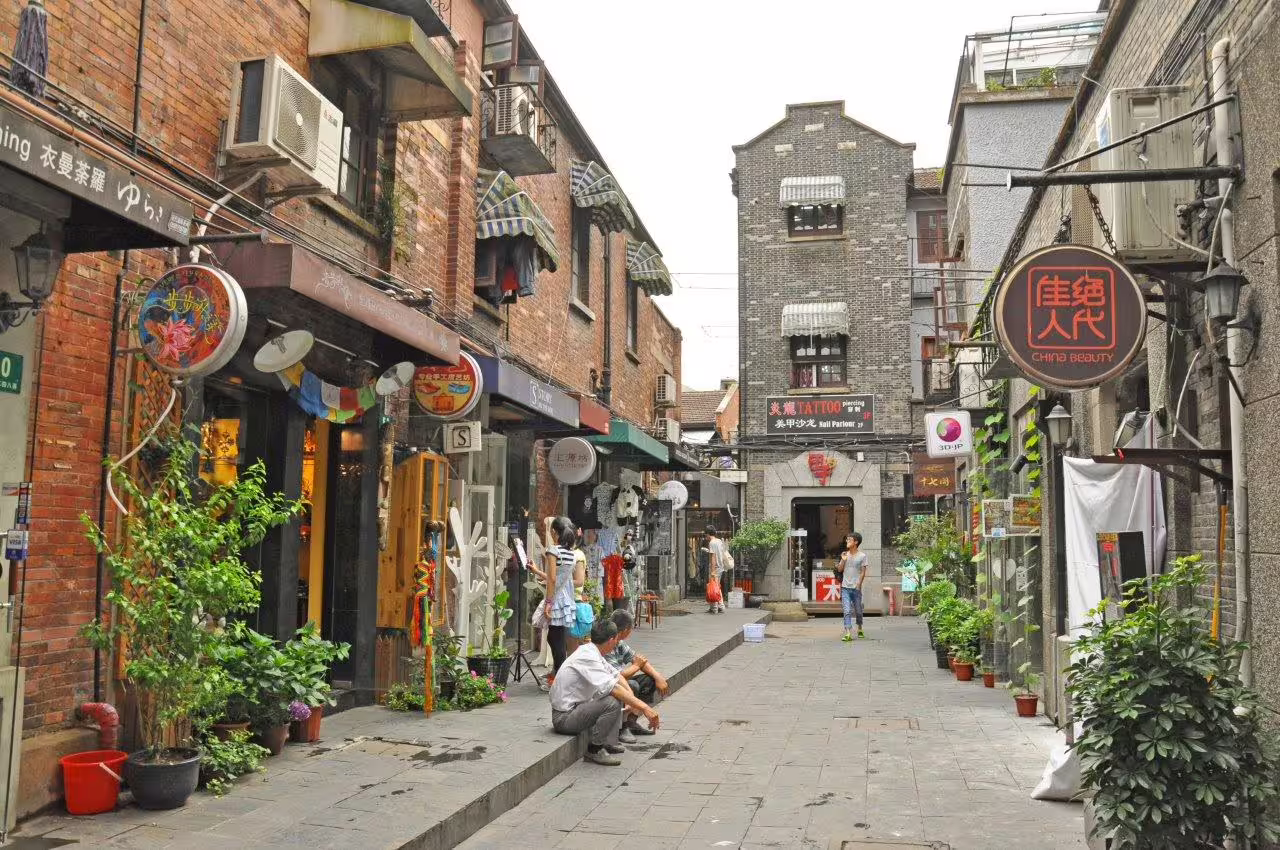 Vibrant alley in Tianzifang, Shanghai, showcasing quaint shops, local art, and bustling urban life.