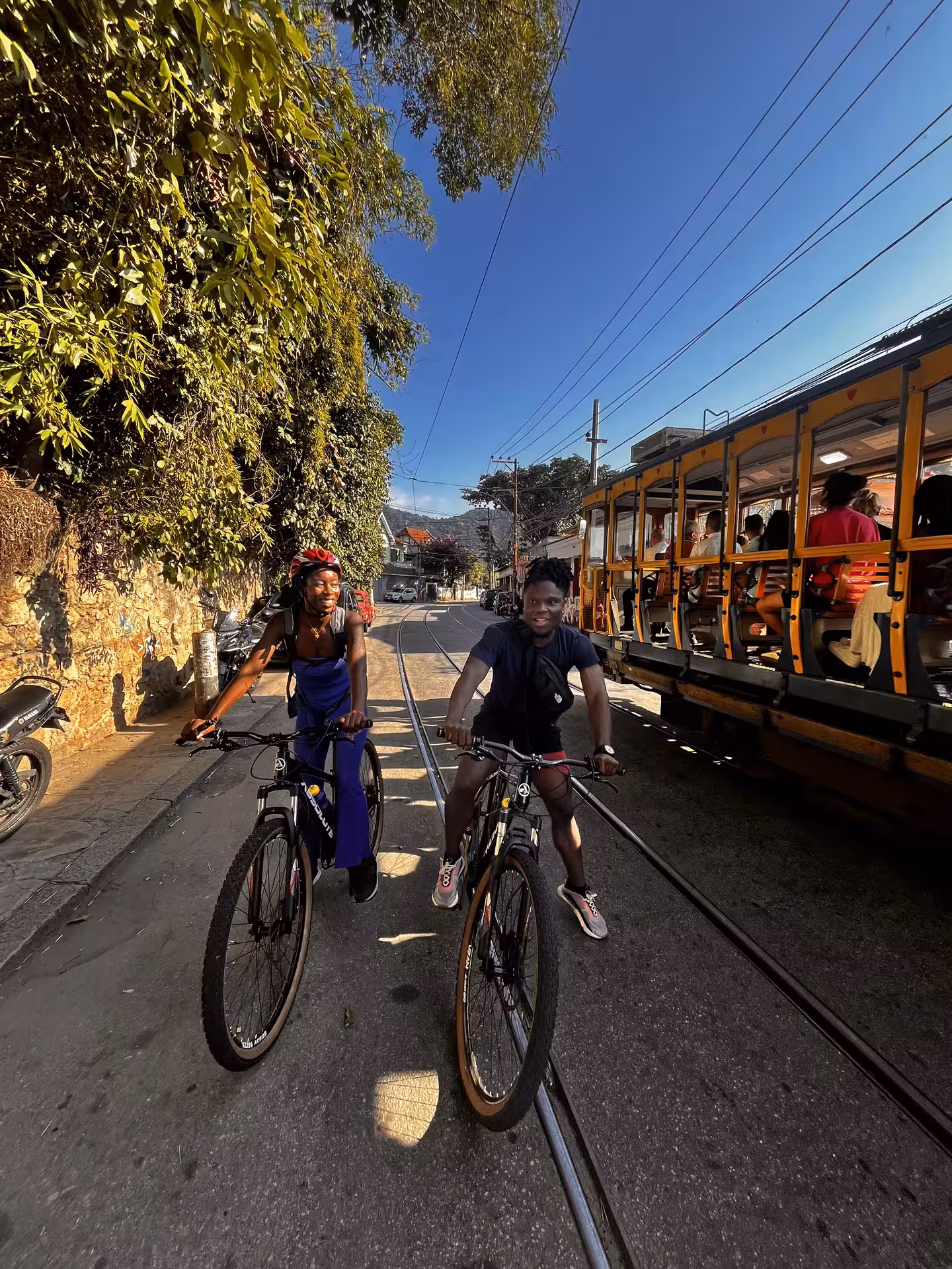 Cyclists riding along Rio tram tracks en route to Tijuca Forest mountain bike tour in the rainforest