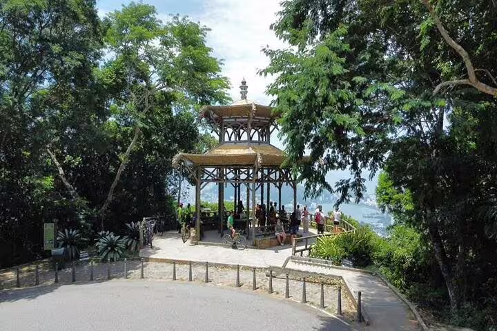 Tourists gather at the Chinese View pavilion in Tijuca Rainforest, enjoying panoramic views of Rio's scenic landscape.