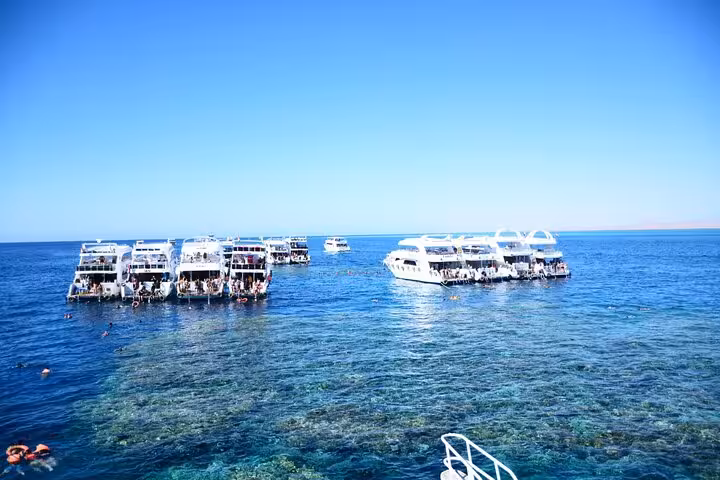 Boats anchored above Red Sea reefs during Tiran Island full-day snorkeling cruise with Sharm El Sheikh hotel pickup