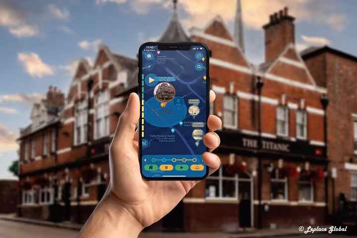 Titanic History Walking Tour app displayed on smartphone with The Titanic pub and historic Southampton buildings in background