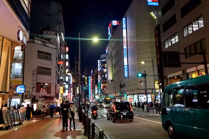 Vibrant Tokyo street at night with illuminated signs and bustling activity on a guided tour of Tokyo, Mt. Fuji, and Hakone.