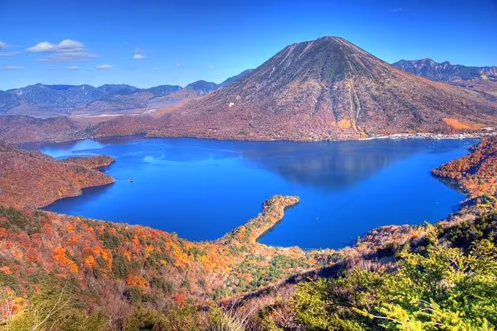 Stunning autumn view of Lake Chuzenji reflecting Mount Nantai on a Tokyo to Nikko private guided tour.