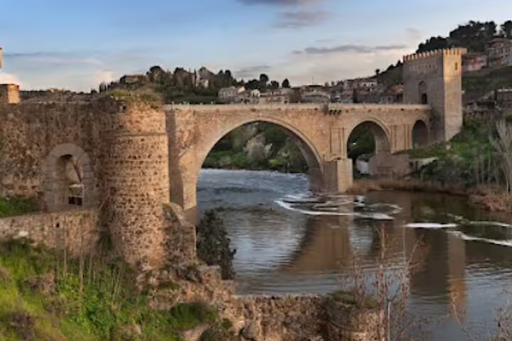 Toledo Alcantara Bridge over Tagus River at sunset, scenic highlight on private half-day Toledo minivan tour