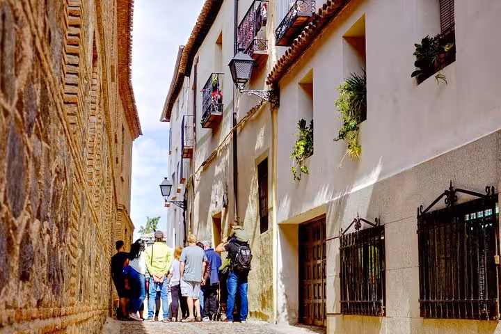 Visitors admire the narrow cobblestone alleys and charming balconies of Toledo during a guided day trip from Madrid.