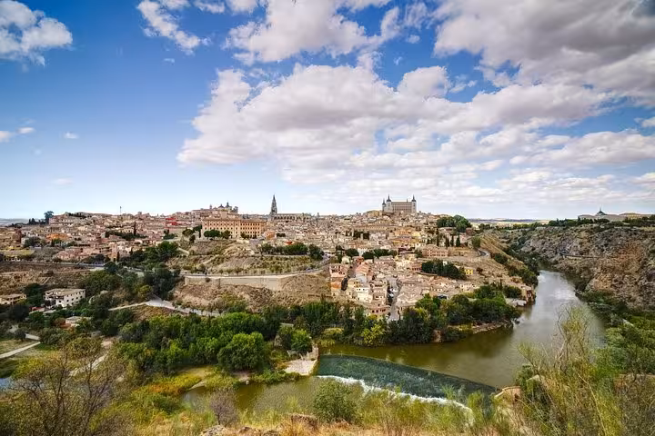 Panoramic view of Toledo's historic skyline and Tajo River, showcasing landmarks on a half-day tour from Madrid.