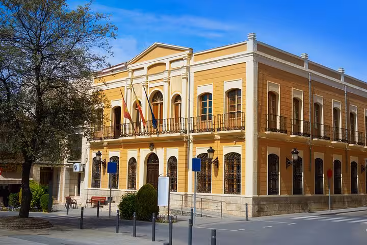 Elegant neoclassical building with Spanish flags in the heart of Toledo's historic center.