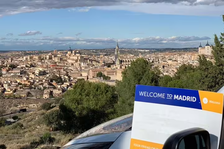 Scenic Toledo skyline viewpoint on private day trip from Madrid, with tour sign and car in foreground