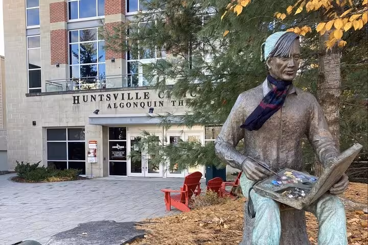 Bronze Tom Thomson statue holding a painter palette outside Huntsville Civic Centre Algonquin Theatre on GPS walking tour