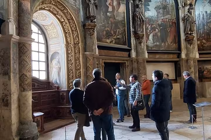 Tour group captivated by the stunning paintings and carvings inside the Convent of Christ in Tomar, Portugal.