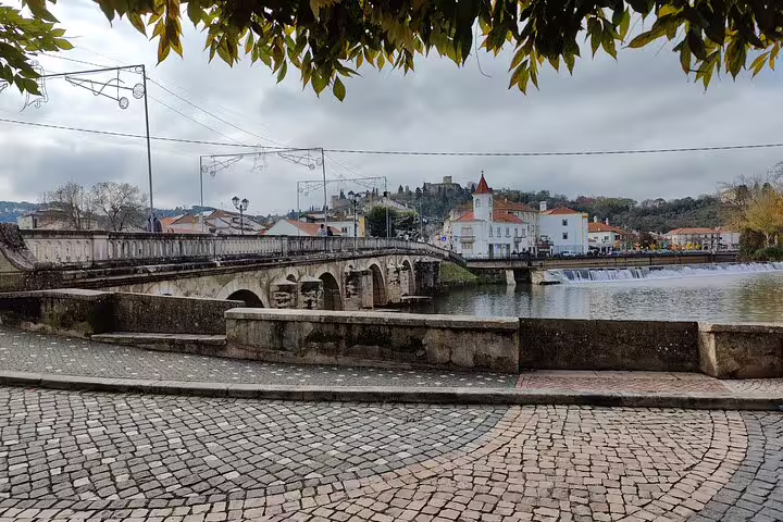 Scenic view of Tomar's historic bridge and riverfront, perfect for exploring the Knights Templar heritage on a private day tour.