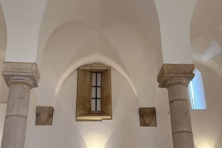 Interior of Tomar's historic synagogue with elegant arches and stone columns, highlighting medieval architecture.