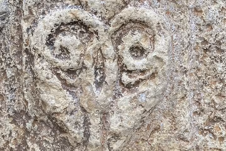 Close-up of ancient stone carving with intricate spiral design in Tomar's historic synagogue.