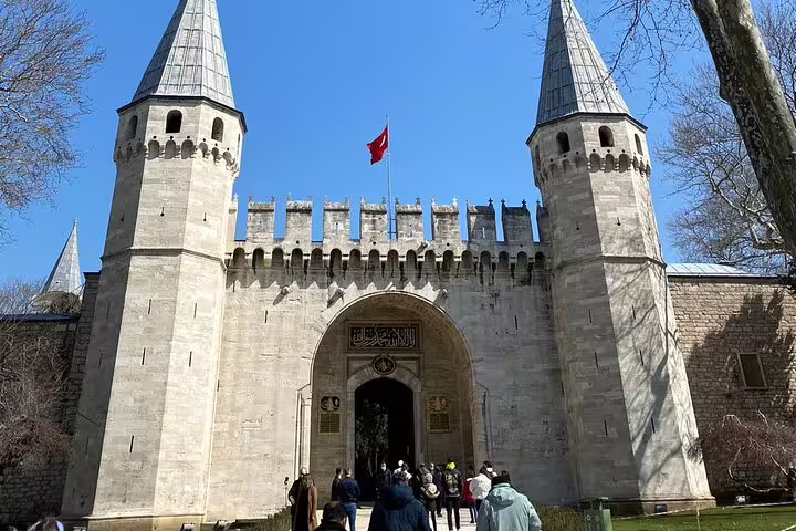 Topkapi Palace Imperial Gate in Istanbul with visitors and Turkish flag on a 10-day private guided Turkey tour