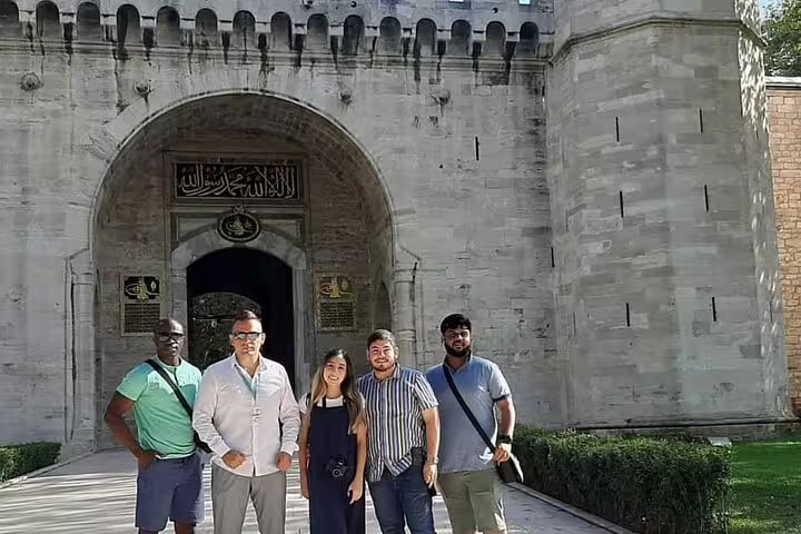 Tourists enjoying a guided visit at the historic entrance of Topkapi Palace in Istanbul, ideal for private tours.
