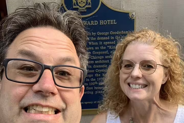 Couple taking selfie in front of historic King Edward Hotel Ontario Heritage plaque in Toronto