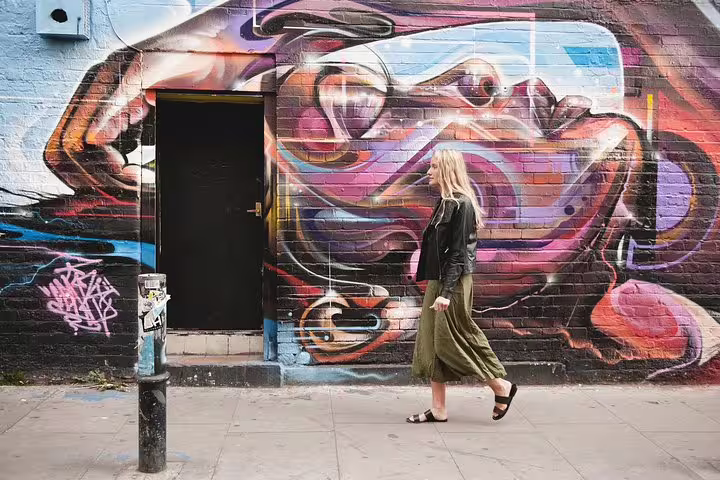 Traveler walks past vibrant Toronto street art mural on a private tour with personal travel photographer
