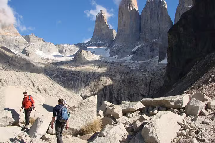 Adventurers hike through rocky paths with breathtaking views of Torres del Paine's towering granite spires.