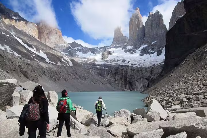 Hikers approach the stunning Torres del Paine peaks and turquoise lake on a full-day trekking adventure in Patagonia.
