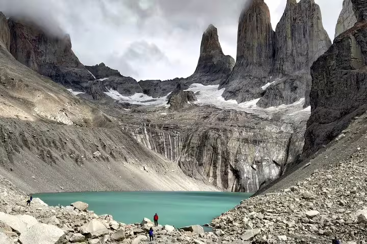 Breathtaking view of turquoise lake and towering granite peaks on a Torres del Paine trekking adventure.