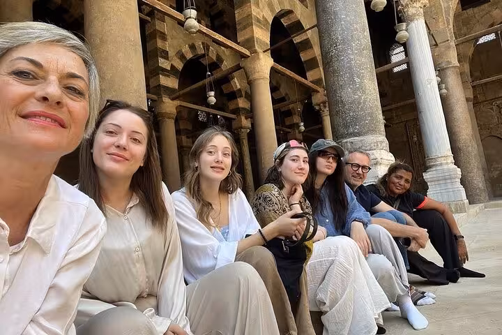 Tour group resting in historic Cairo mosque courtyard, part of 3-day private Giza Cairo Alexandria tour