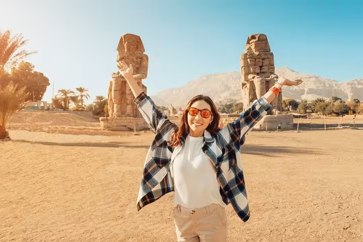 Happy tourist at Colossi of Memnon, Luxor highlights on 2-day Hurghada tour with hotel, balloon and Nile boat