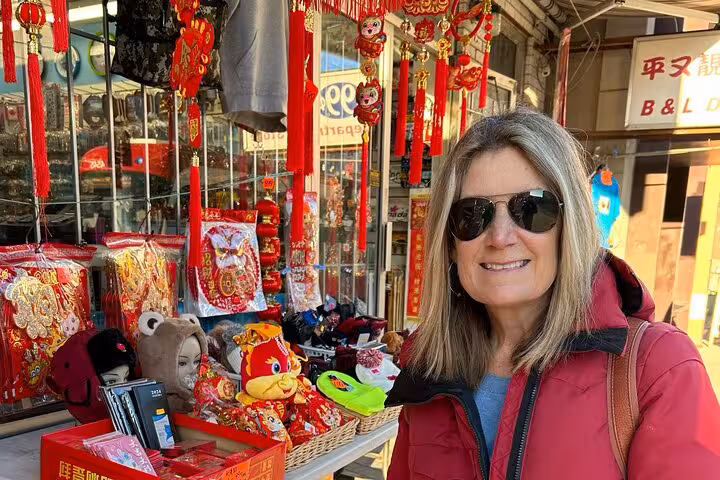 Smiling tourist exploring Toronto Chinatown on a self-guided GPS walking tour surrounded by vibrant cultural shops