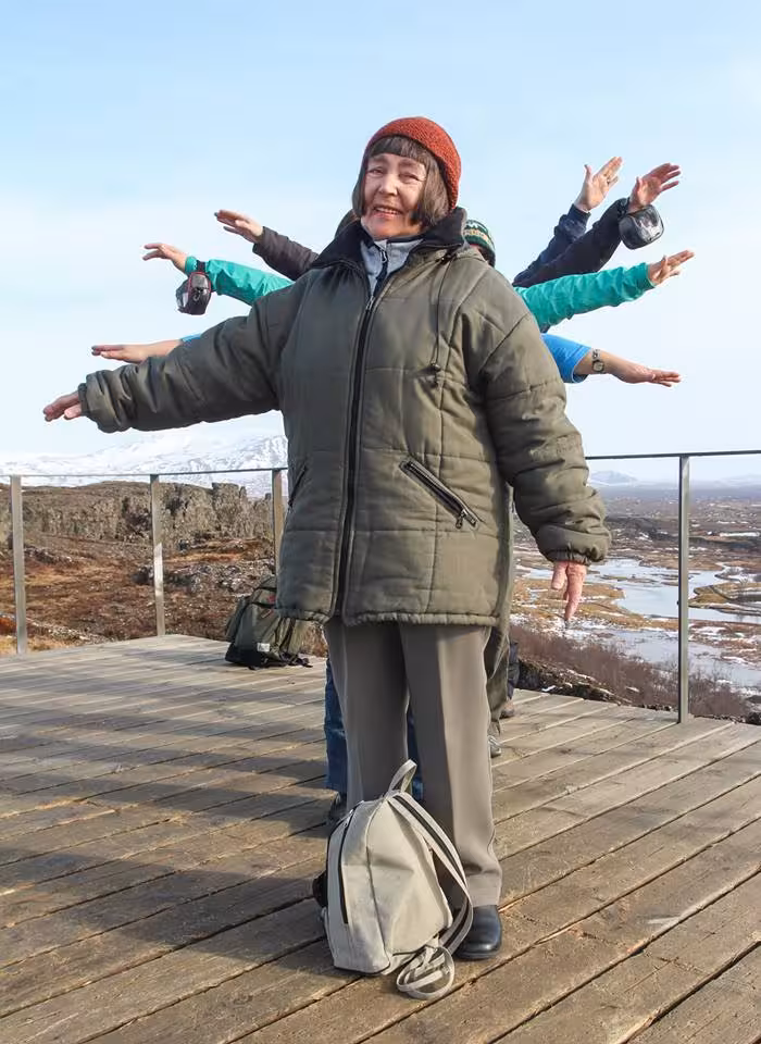 Tourist posing with multiple arms effect on scenic Icelandic overlook near Akureyri in winter