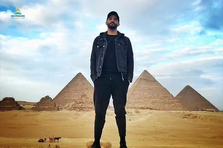 Tourist standing by the Giza Pyramids in Cairo during a 2-day Cairo and Luxor tour from Hurghada with transfers