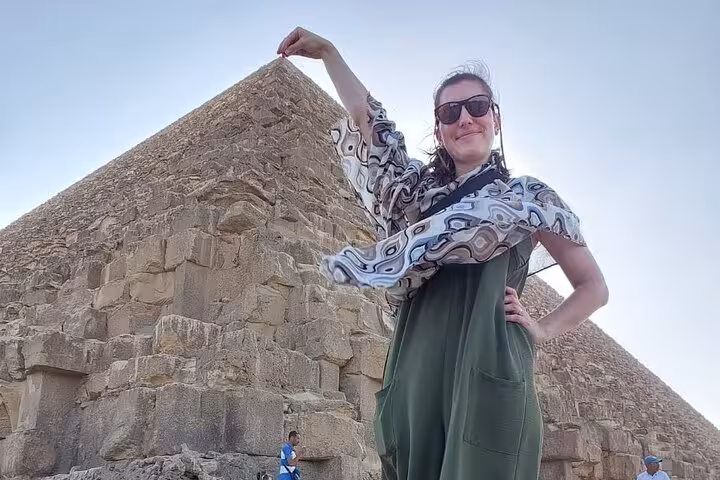 Tourist posing by the Great Pyramid of Giza on Hurghada to Cairo tour, Egypt pyramids visit