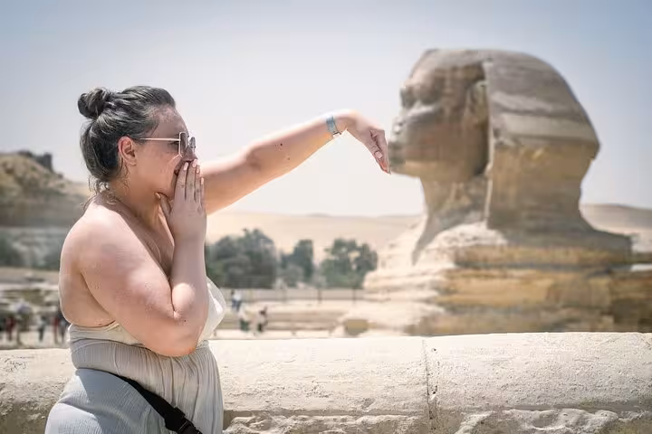 Tourist posing by the Great Sphinx of Giza on a Cairo full-day customized adventure with guided sightseeing