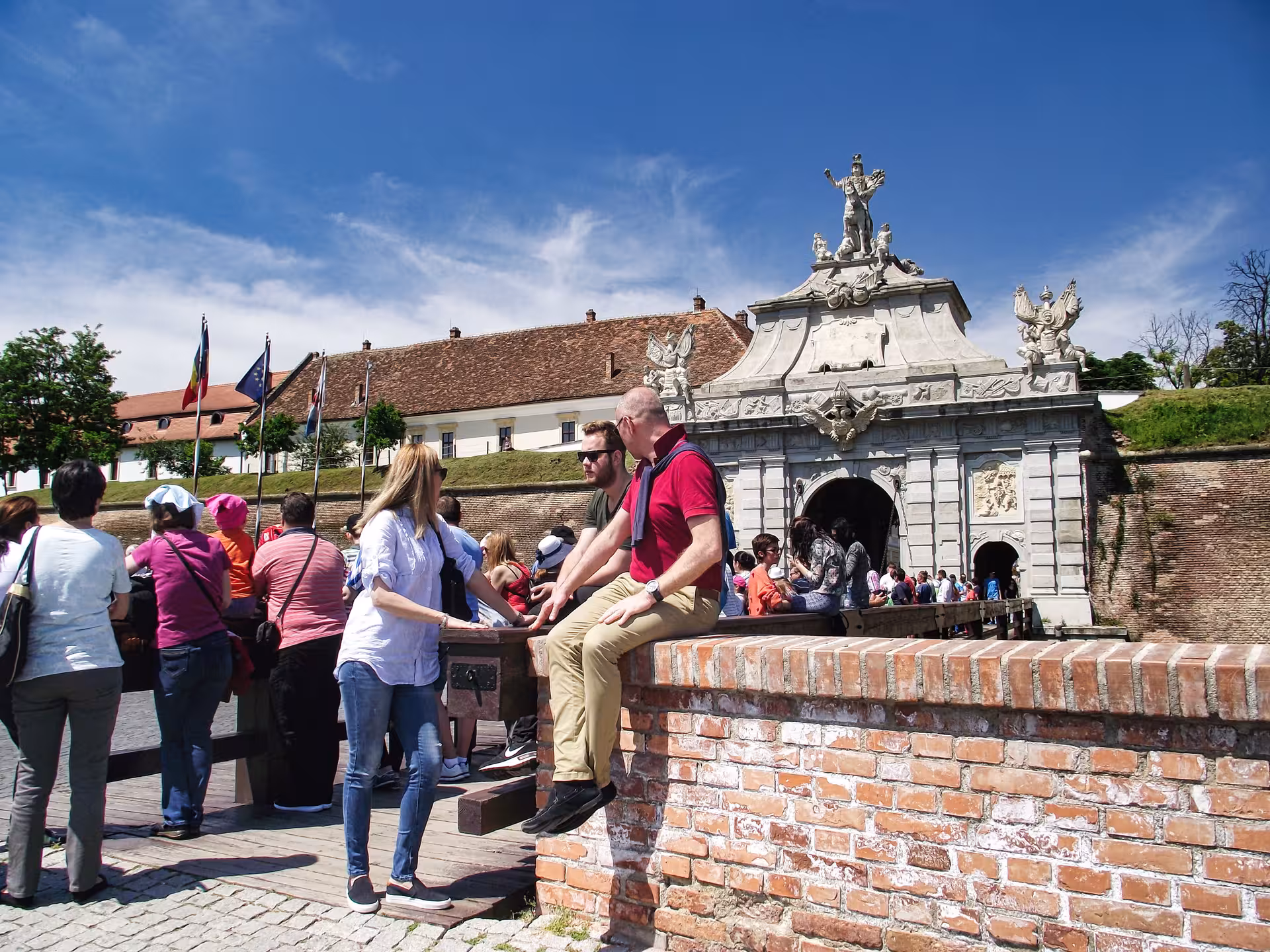 Tourists exploring the ornate baroque gate of Alba Iulia fortress on a Best of Transylvania castles tour