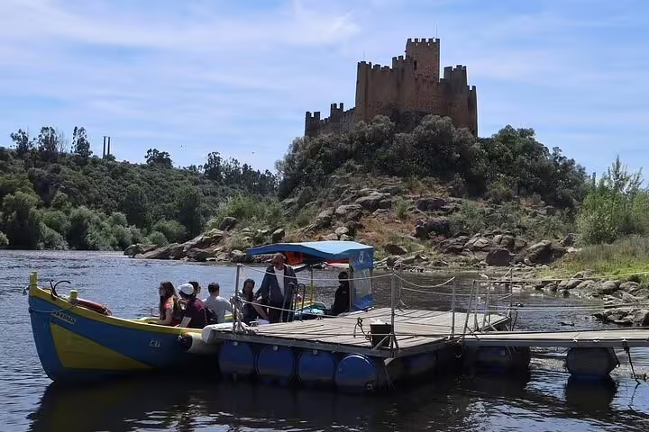 Tourists on a boat near Almourol Castle on the Tagus River, a highlight of the Tomar and Almourol tour from Lisbon.