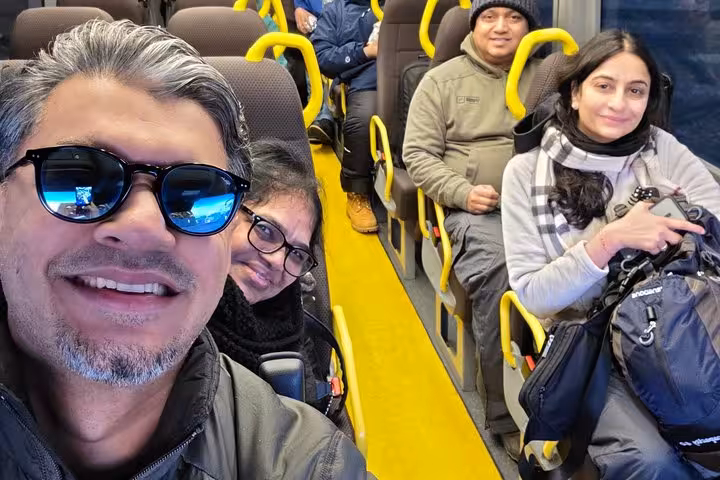 Group of tourists smiling on a bus during South Coast full-day tour from Reykjavik