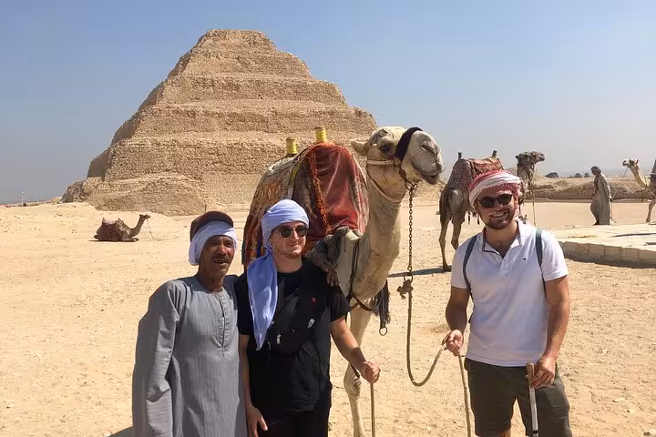 Tourists with camel at Saqqara Step Pyramid on all-inclusive private day trip from Cairo Airport layover