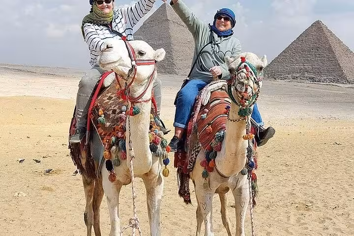 Tourists riding camels near the Giza Pyramids, Cairo stop on 2-day Sharm El Sheikh to Cairo and Luxor tour