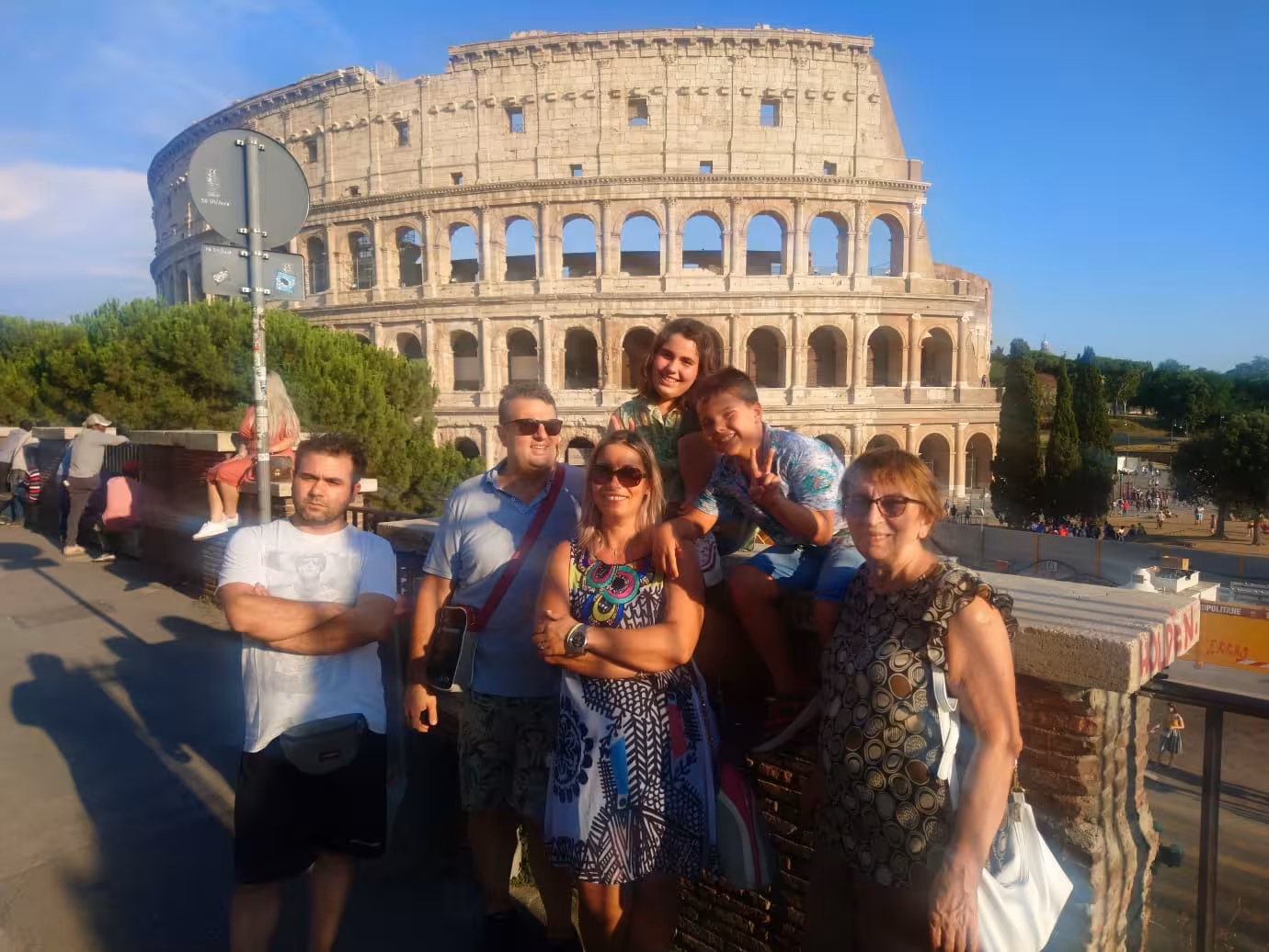 Group of tourists smiling in front of the Colosseum, enjoying the Sant'Angelo Castle Combo Tour in Rome.