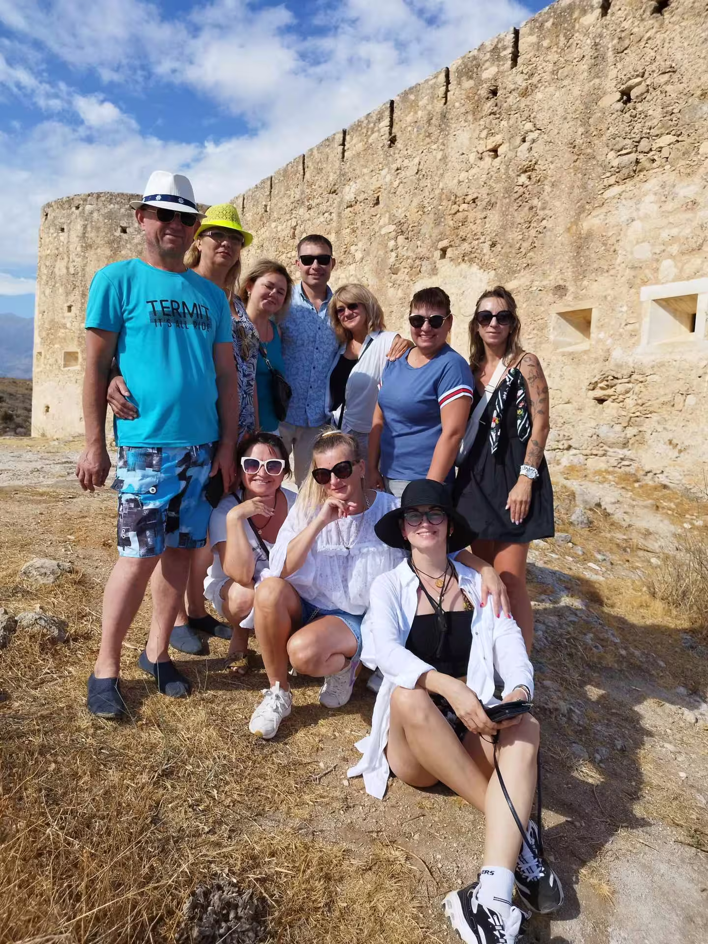 Group of tourists exploring historical ruins in Aptera on a sunny day during a semi-private tour.