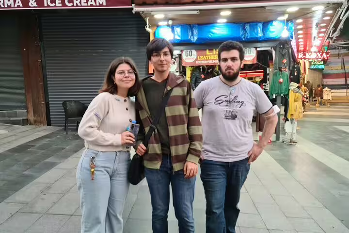Three tourists posing together on a shopping street in Kusadasi, Turkey
