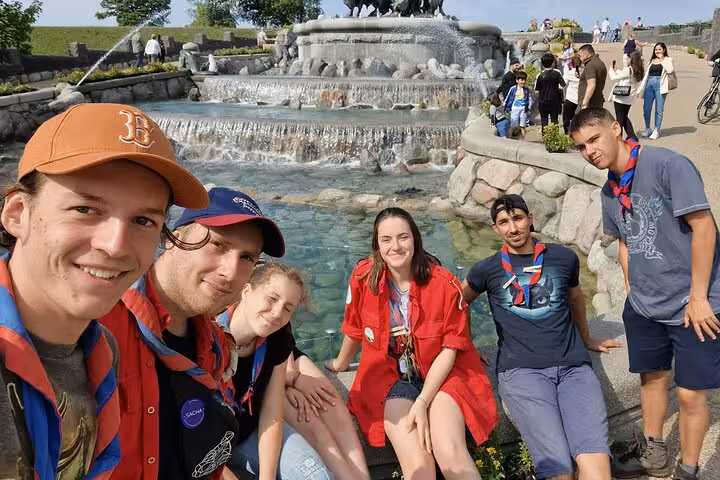 Group of young tourists taking selfie at Gefion Fountain in Copenhagen on a sunny day