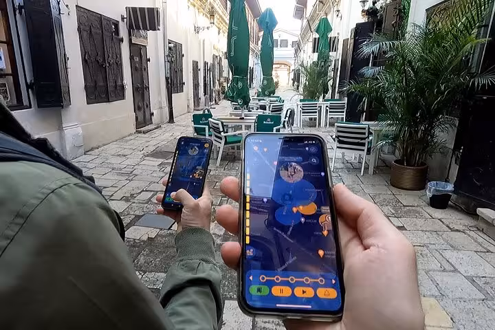 Tourists using GPS walking tour app on smartphones exploring Jewish Bucharest historic courtyard streets