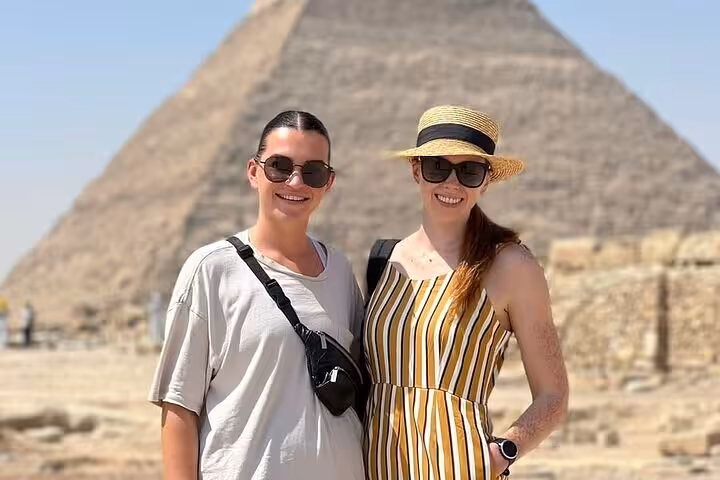 Tourists posing by the Great Pyramid of Giza, photo stop on Giza Pyramids Saqqara Memphis day tour from Cairo