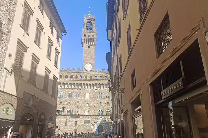 Tourists walking toward Palazzo Vecchio in Florence’s medieval center on a guided Florence and Pisa excursion from La Spezia